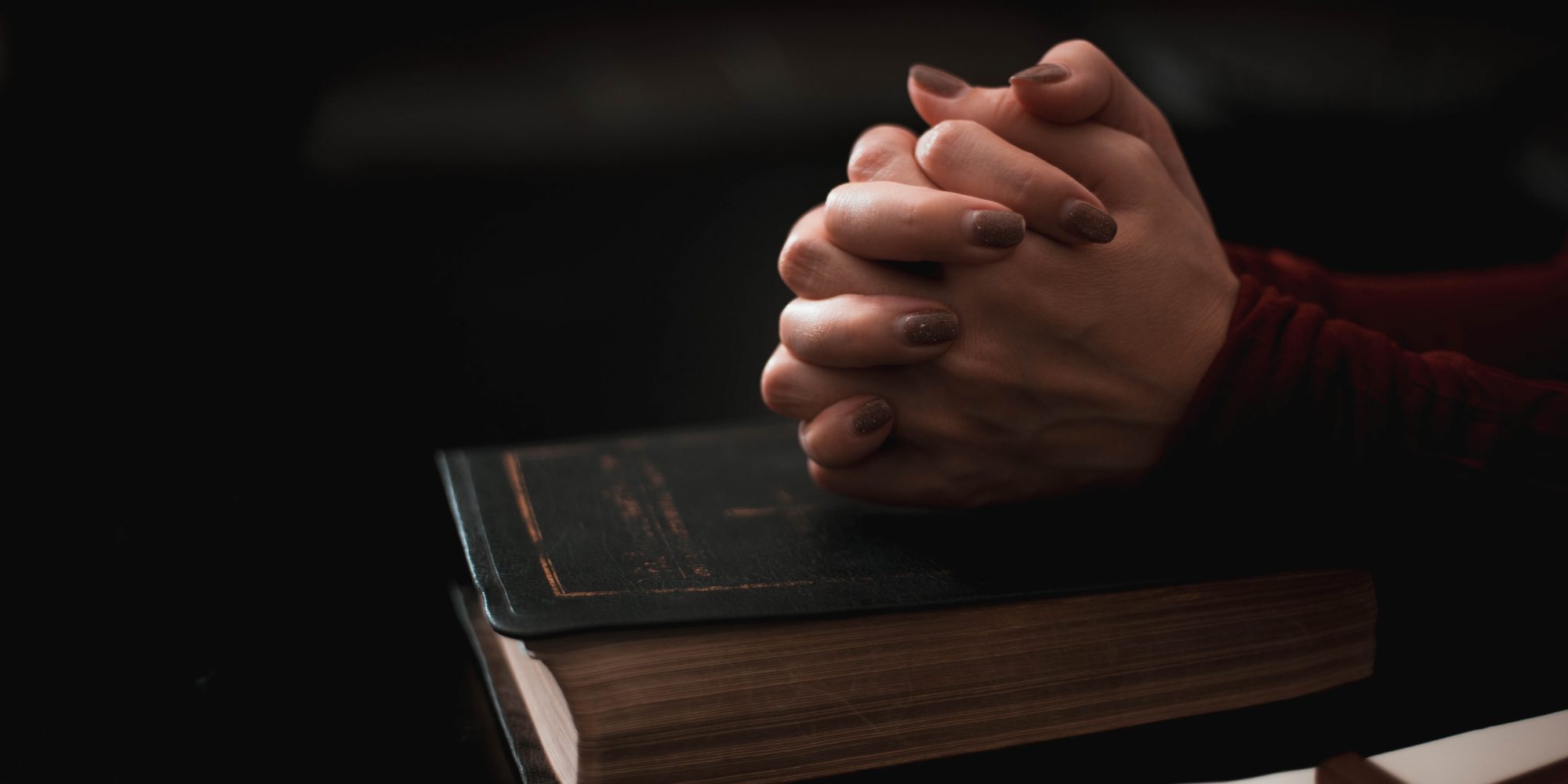 Woman hand praying on holy bible in the morning.
